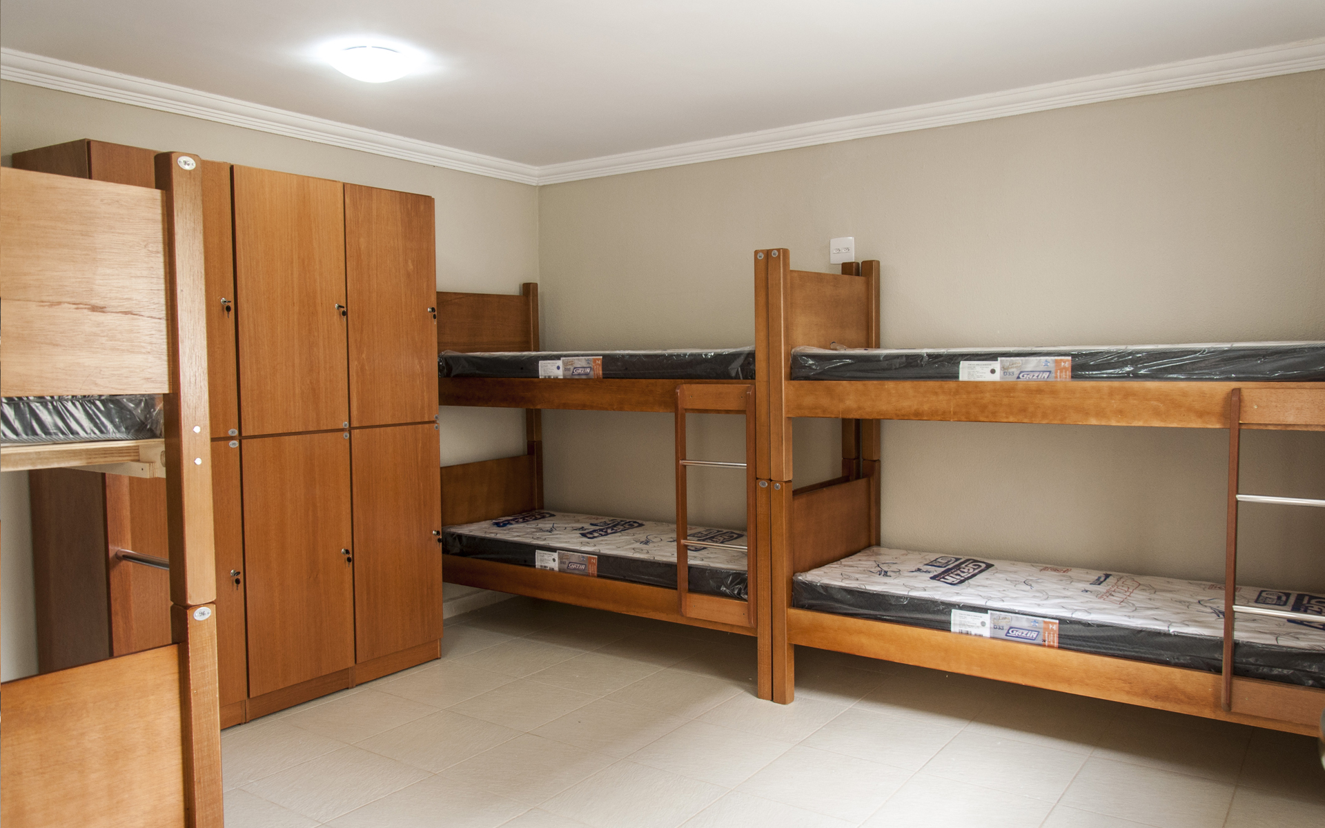 Quarto compartilhado da República Bem-Estar com beliches, colchões D33 e guarda-roupas individuais